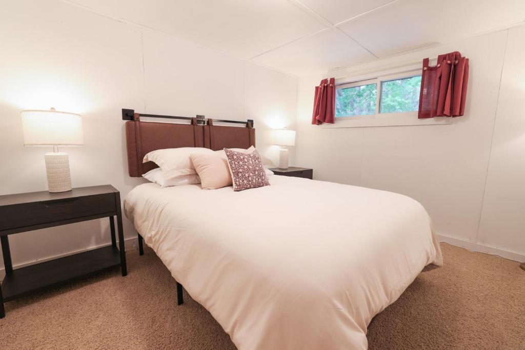 een witte slaapkamer met een bed en een raam bij Wilderness West Resort Cabin 1 in Colville