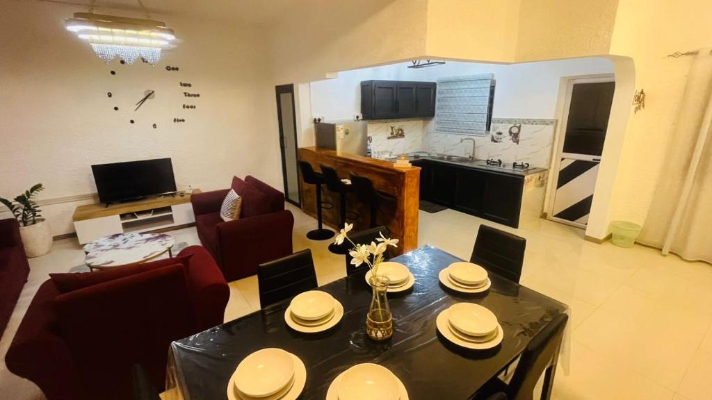 a living room with a table and a kitchen at Zilwest Villa in Flic-en-Flac