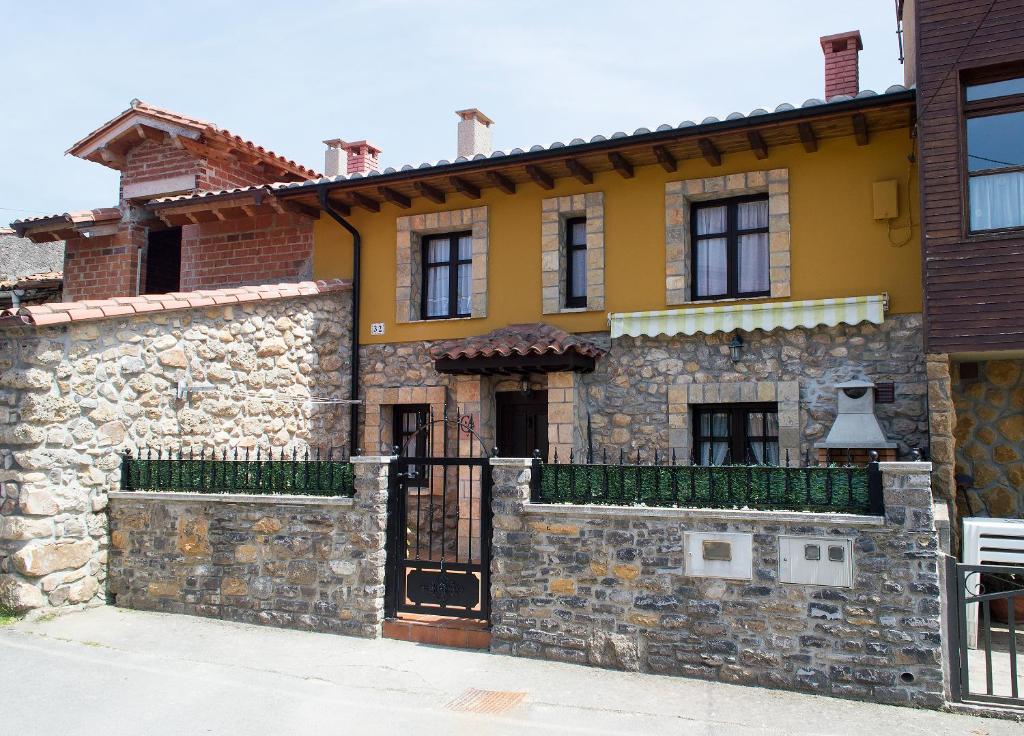 una casa di pietra con un cancello e un muro di pietra di La Ermita a Loroñe
