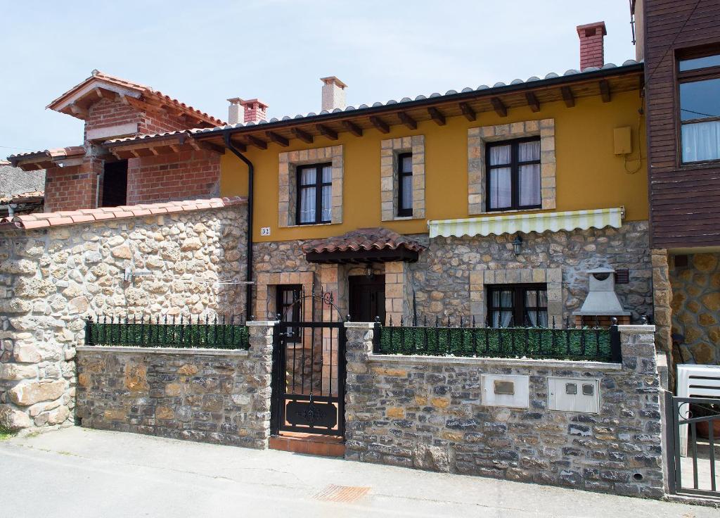 Casa de piedra con puerta y pared de piedra en La Ermita, en Loroñe