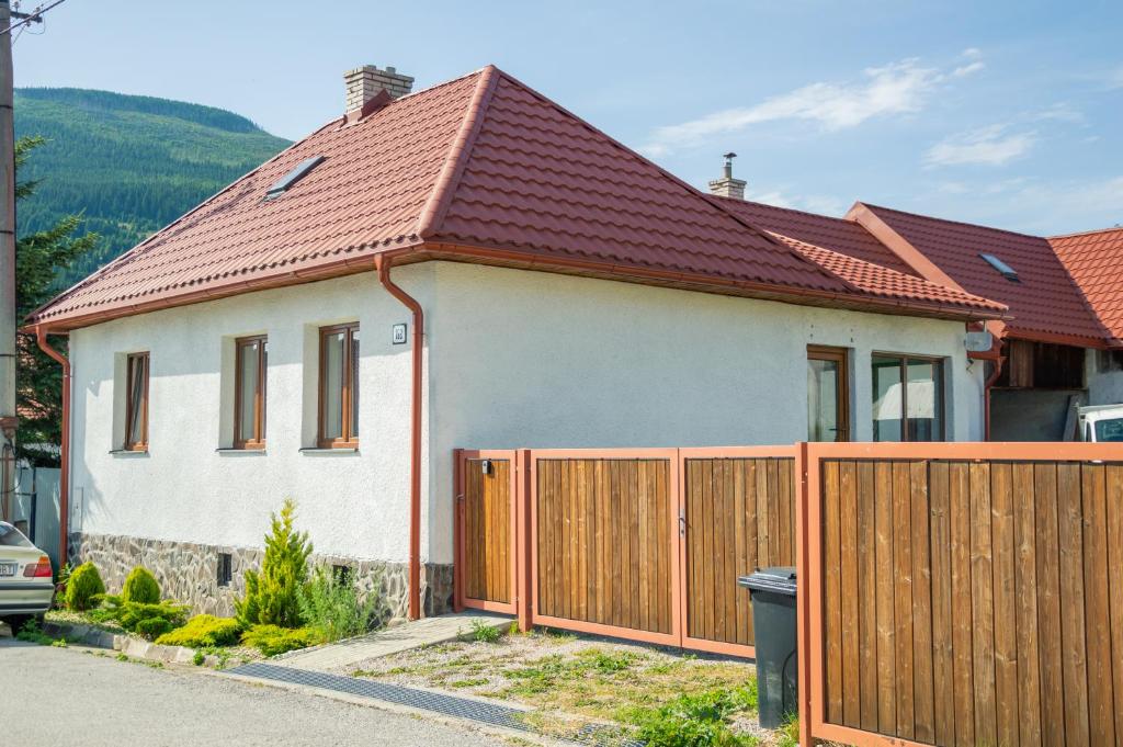 una casa con una valla de madera delante de ella en Chata Homola - Telgárt Resort, en Telgárt