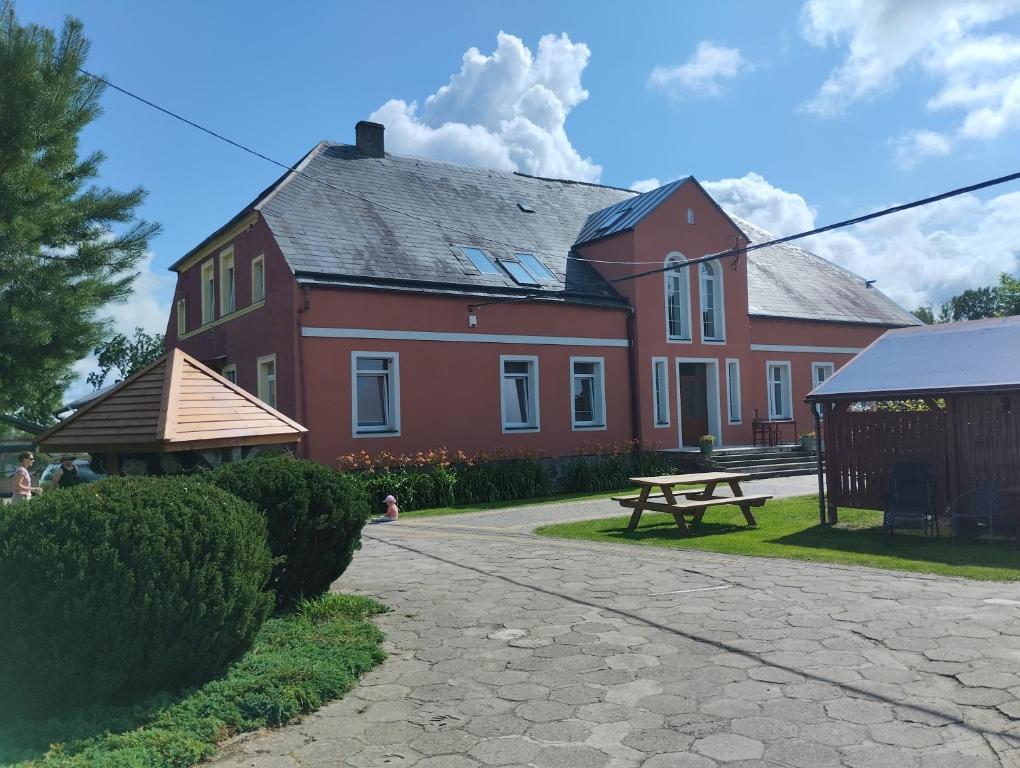 a red house with a picnic table in front of it at Agroturystyka Goliat in Zapolice
