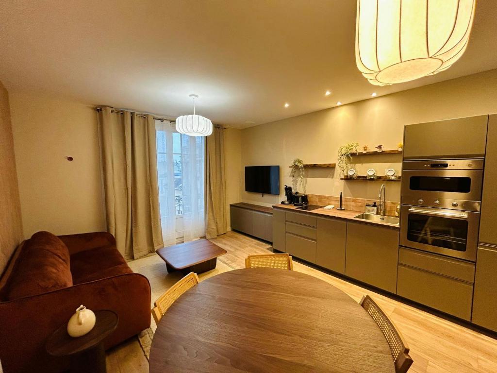 un salon avec une table et une cuisine dans l'établissement Lappart Rémois Balcon Centre-ville, à Reims