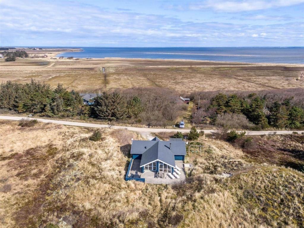 an aerial view of a house on a hill next to the ocean at 555-Hvide-Sande-Tornbjerrevej-32 in Havrvig