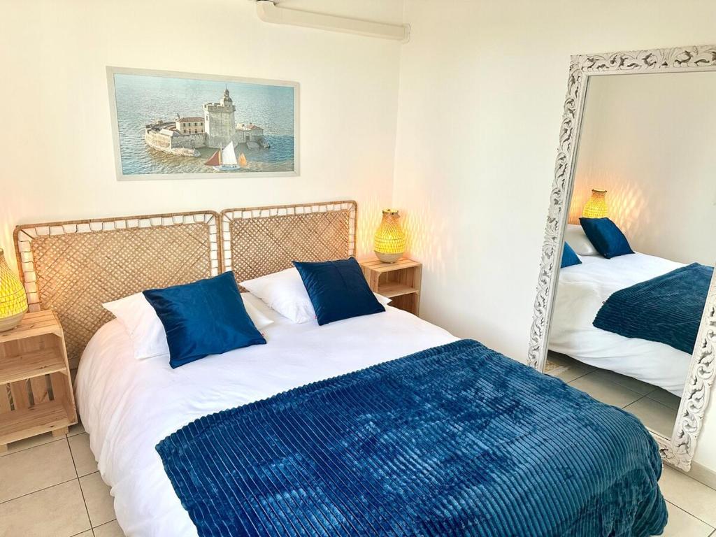 a bedroom with two beds and a mirror at Maison La Luzala 2 bedrooms beach and port within walking distance in Saint-Pierre-dʼOléron