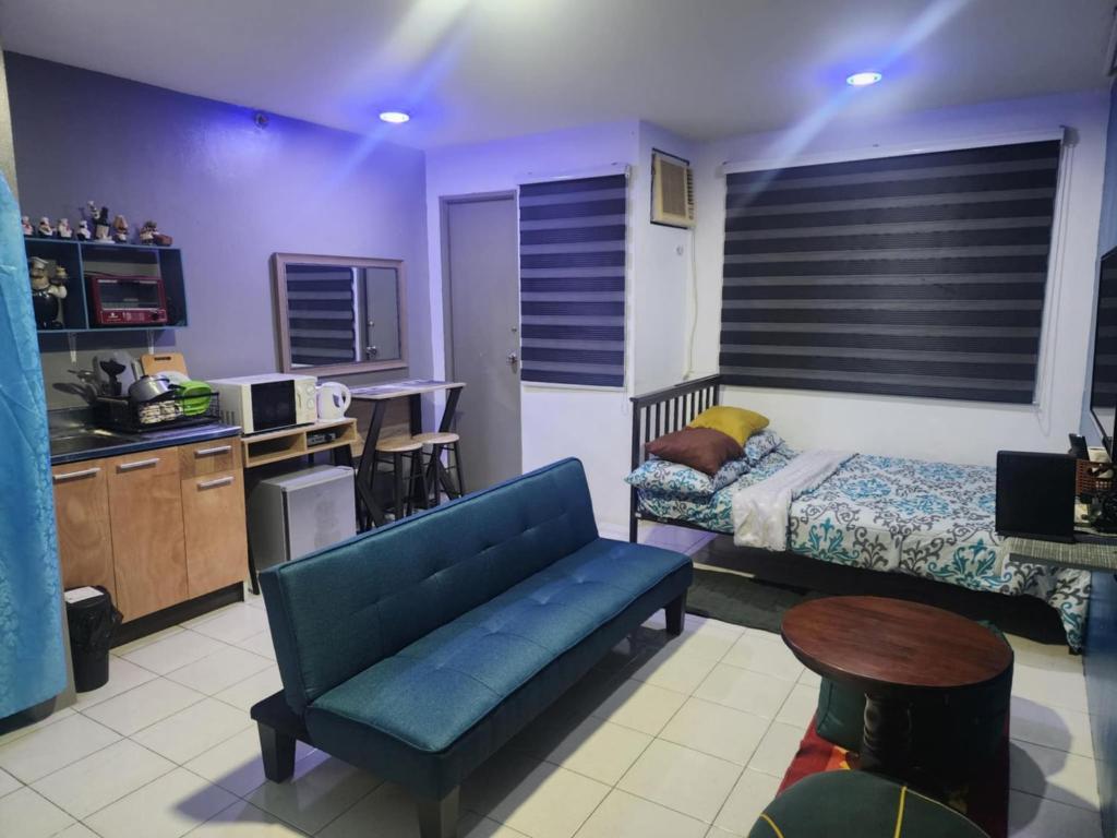 1 dormitorio con sofá azul y cocina en El Cozy Woody Near Enchanted Kingdom, en Santa Rosa