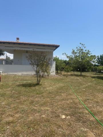 a yard with a house and a green hose at MELIA Holidays & Living in Epanomi