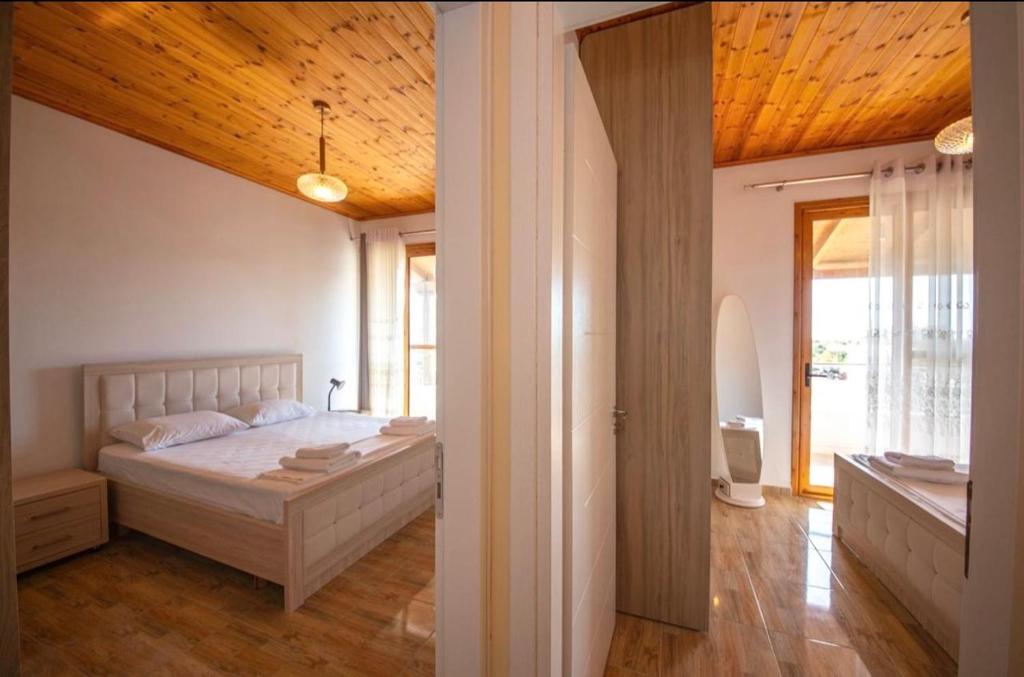 een slaapkamer met een bed met een houten plafond bij Golden Berden Boutique Apart-Hotel in Çukë