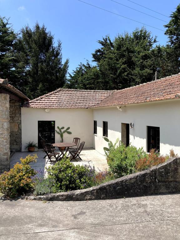 a house with a table and chairs in a yard at Quinta da Faísca Guesthouse in Vila do Conde