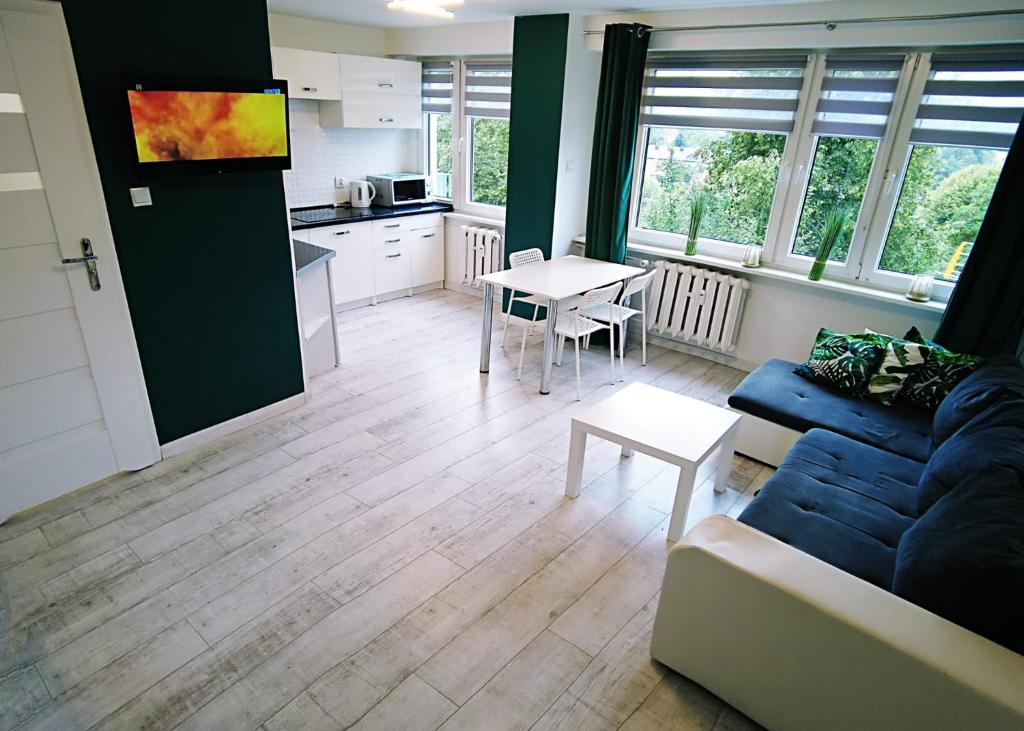 a living room with a couch and a table at Apartament Green Mrągowo-Mazury,blisko plaża, centrum! Wi-fi! in Mrągowo