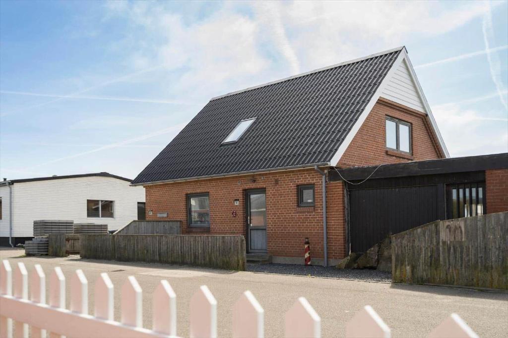 een rood bakstenen huis met een zwart dak bij 8811-Hvide-Sande-Vesterhavsvej-3-stuen in Hvide Sande