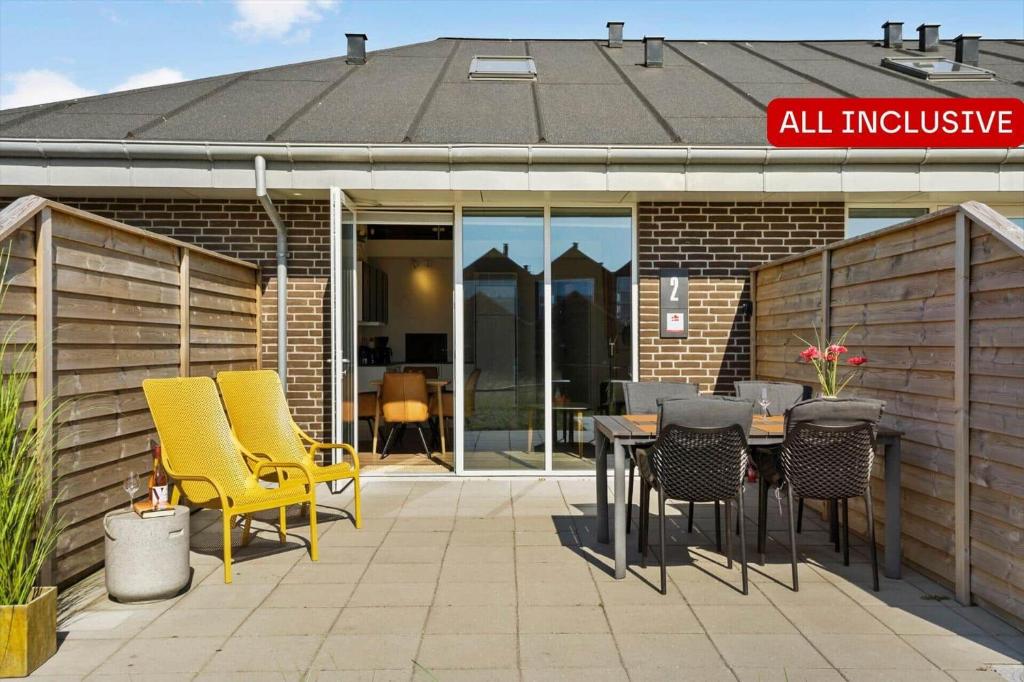a patio with chairs and a table in front of a building at 777-Hvide-Sande-Norregade-2-nr-2 in Hvide Sande