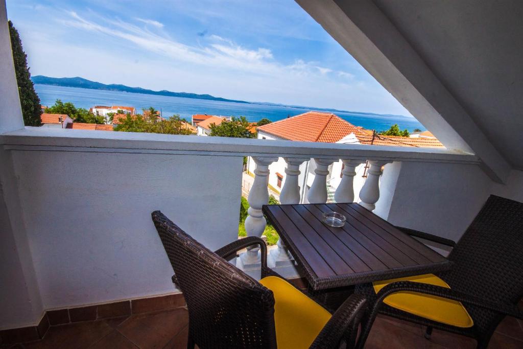 a balcony with a table and chairs and a view of the ocean at Apartman Joso in Diklo
