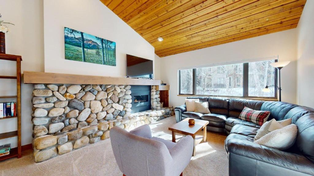 a living room with a couch and a stone fireplace at Bridgepoint Condo 30 in Ketchum