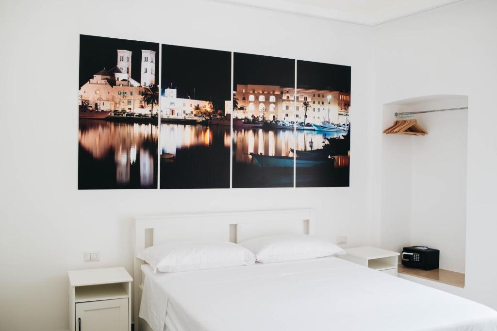 una camera da letto con un letto e un dipinto sul muro di Casa Del Capitano - Appartamento Accogliente - Molfetta a Molfetta