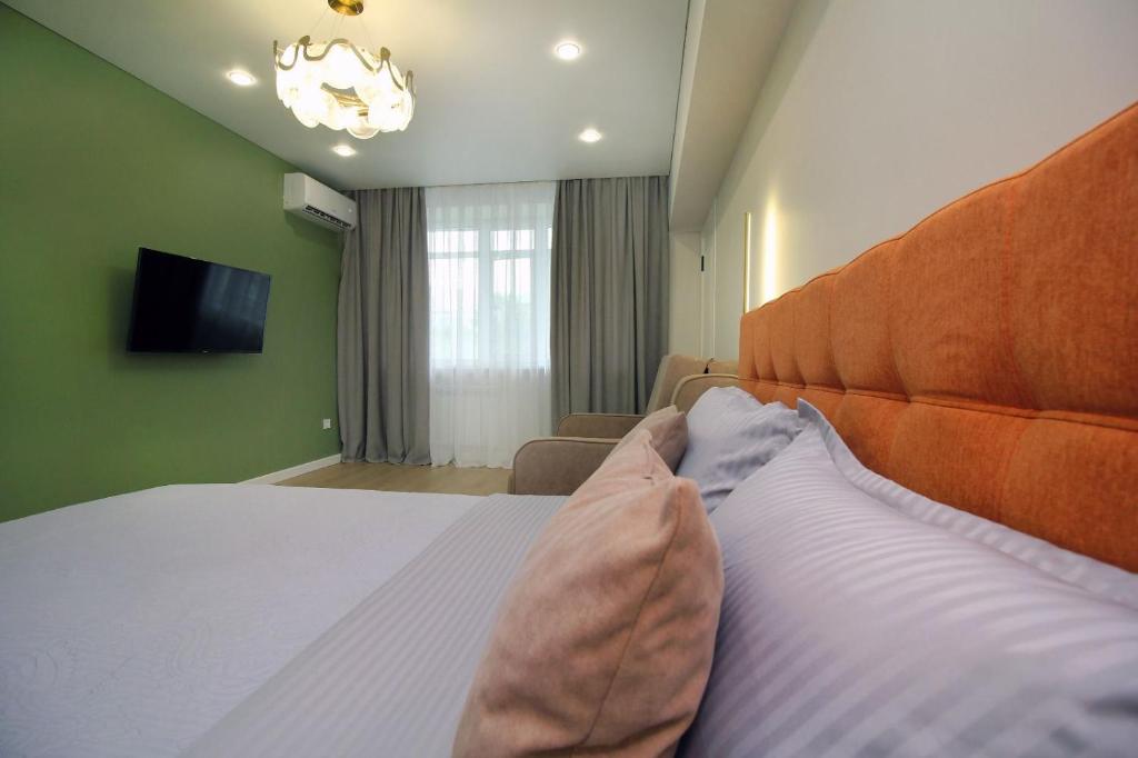 a bedroom with a large bed and a television at Center Almaty in Almaty