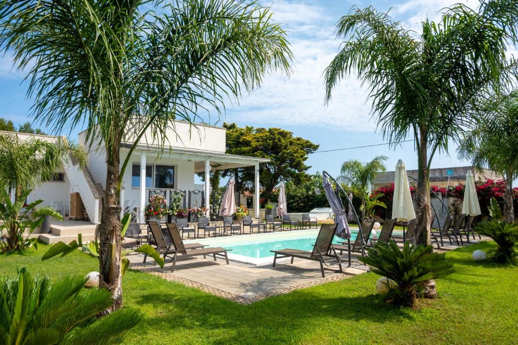 a villa with a swimming pool and palm trees at VILLA LEONARDO SAN FOCA - Room, Pool & Restaurant in San Foca