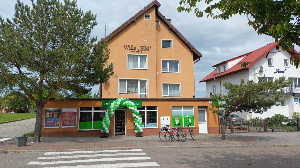 a building with a green arch in front of it at Willa BIM in Rewal