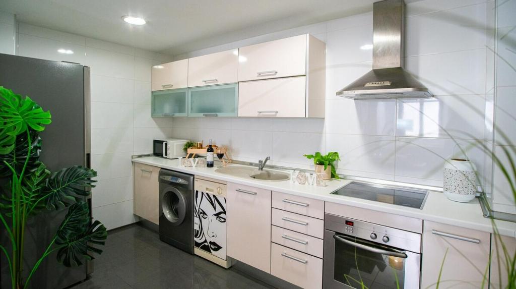 a white kitchen with a sink and a dishwasher at Luxury Signature Apartment with FREE Parking - Malaga in Málaga