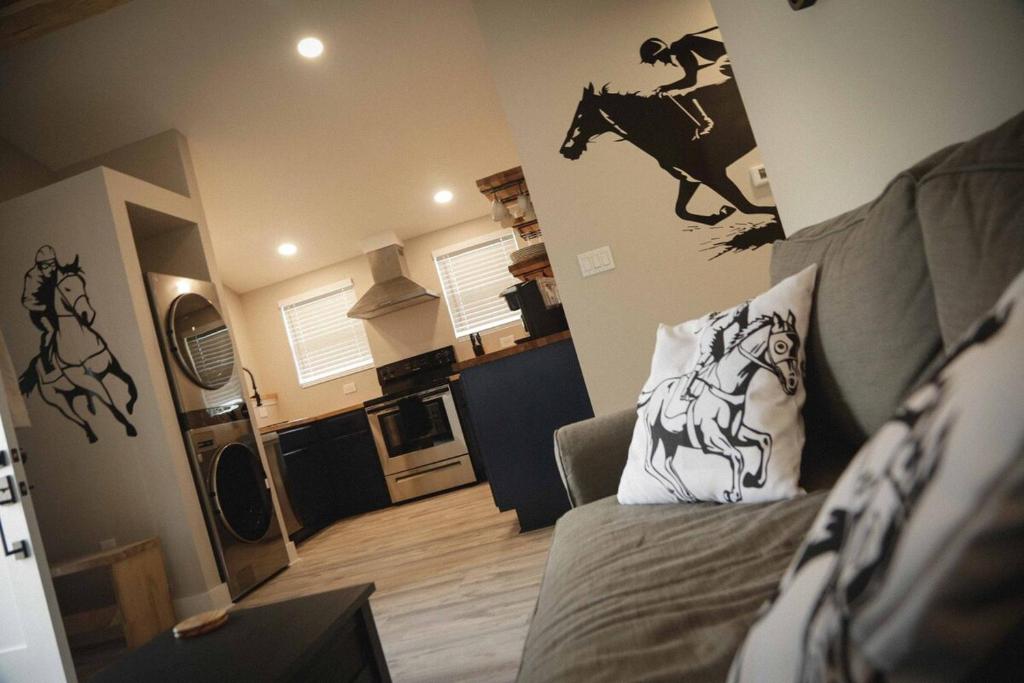 Una sala de estar con un sofá y un mural de caballos en la pared. en Cozy Pool & Hot Tub Retreat by Casino, en Charles Town
