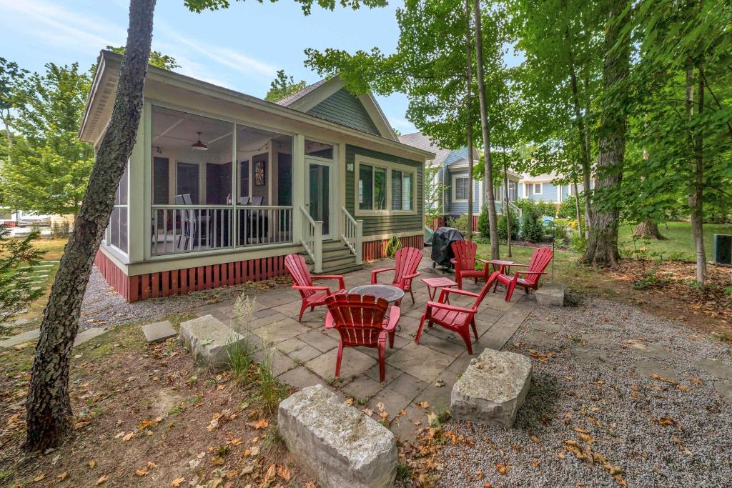 a patio with red chairs and a table in front of a house at The Jack Pine - 50 Hollow in Cherry Valley