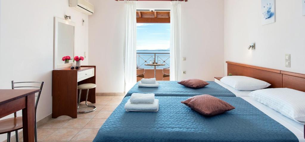 巴尔巴蒂Corfushell Resort Hotel apart的一间卧室，有两张床、一张书桌和一扇窗户