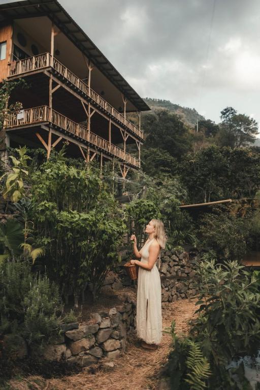 a woman standing in front of a building at Casa Awänímä - Ecological Wellness Sanctuary in Tzununá