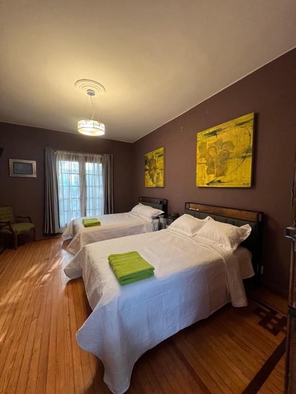 a bedroom with two beds with green towels on them at Habitación Martinique Bed&Breakfast 4 personas en la Condesa in Mexico City