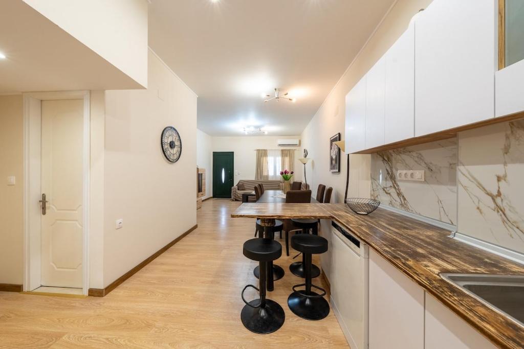 a kitchen with white cabinets and a counter with bar stools at Vasilis Family House in Ágios Rókkos
