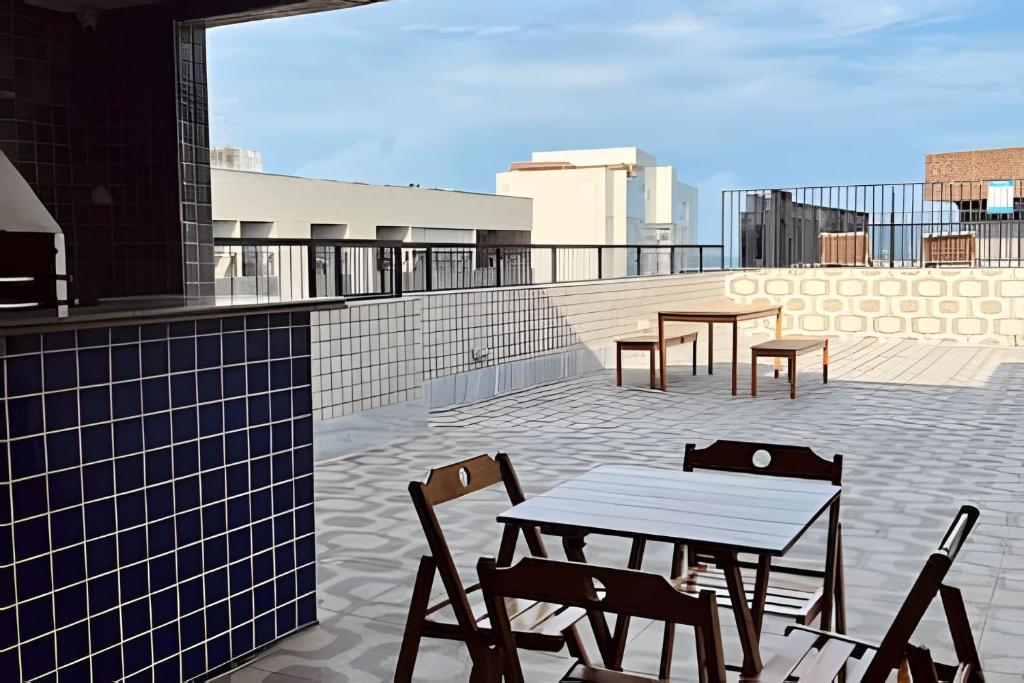 a patio with a table and chairs on a roof at Lindo Flat a poucos passos da praia in Maceió