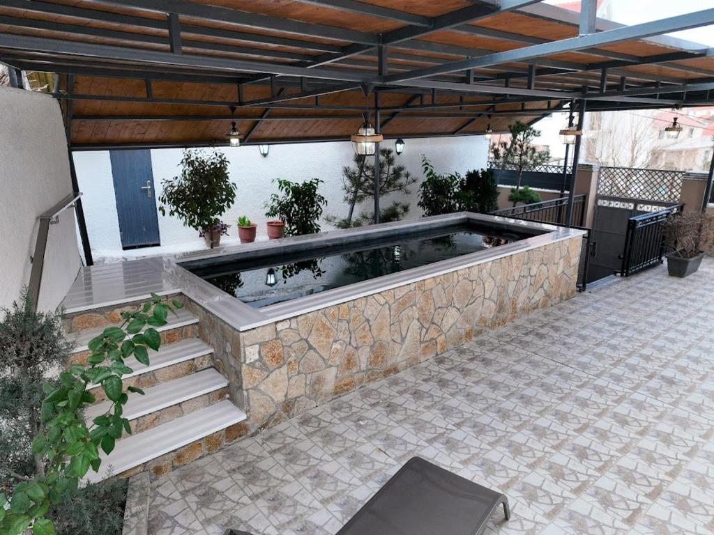 a hot tub in a patio with a stone wall at Lake Retreat Villa in Shkodër