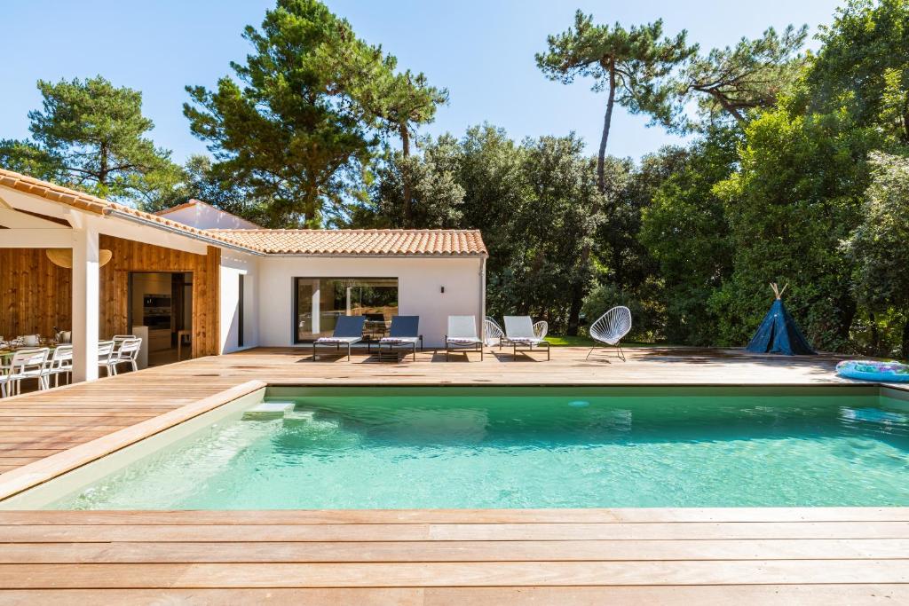 a swimming pool with a deck and a house at Villa évasion familiale avec Piscine & Mer à 200m in Rivedoux-Plage
