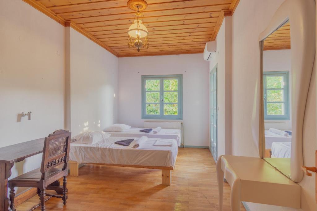 SkiathosにあるLago Skiathos Art Residency & Guesthouseのベッドが2つと机がある部屋