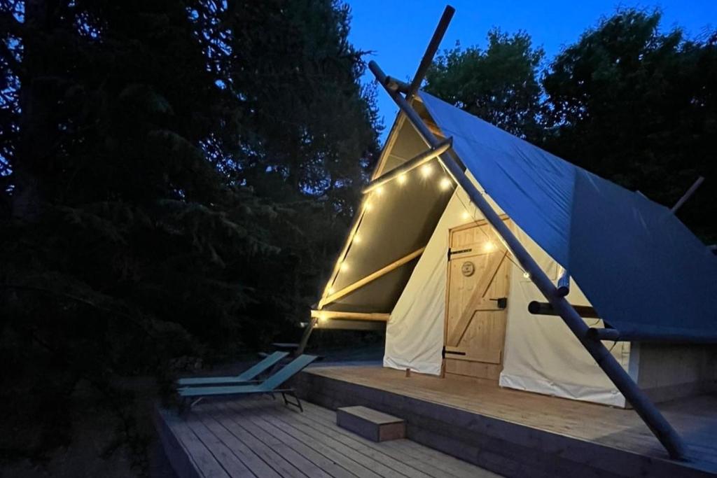 a tent with a light on it on a deck at La Cabane de l'Orpailleur in Gravières