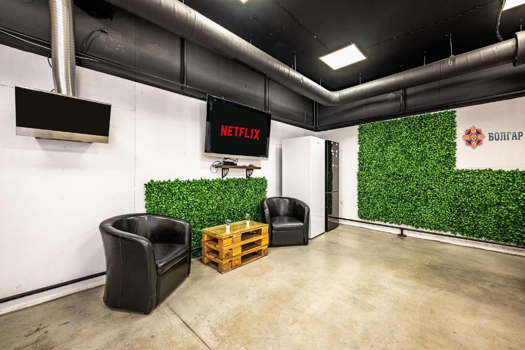 a waiting room with two chairs and a tv on the wall at Heart of the city Hostel in Varna City