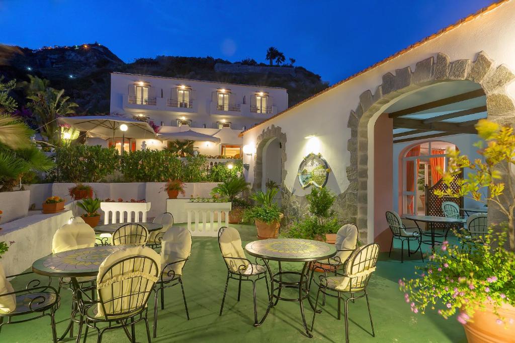 a patio with tables and chairs and a building at Hotel CASA LA VIGNA in Ischia