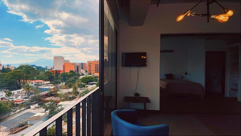a room with a balcony with a view of a city at Apartamento Zona 10 in Estación Pamplona