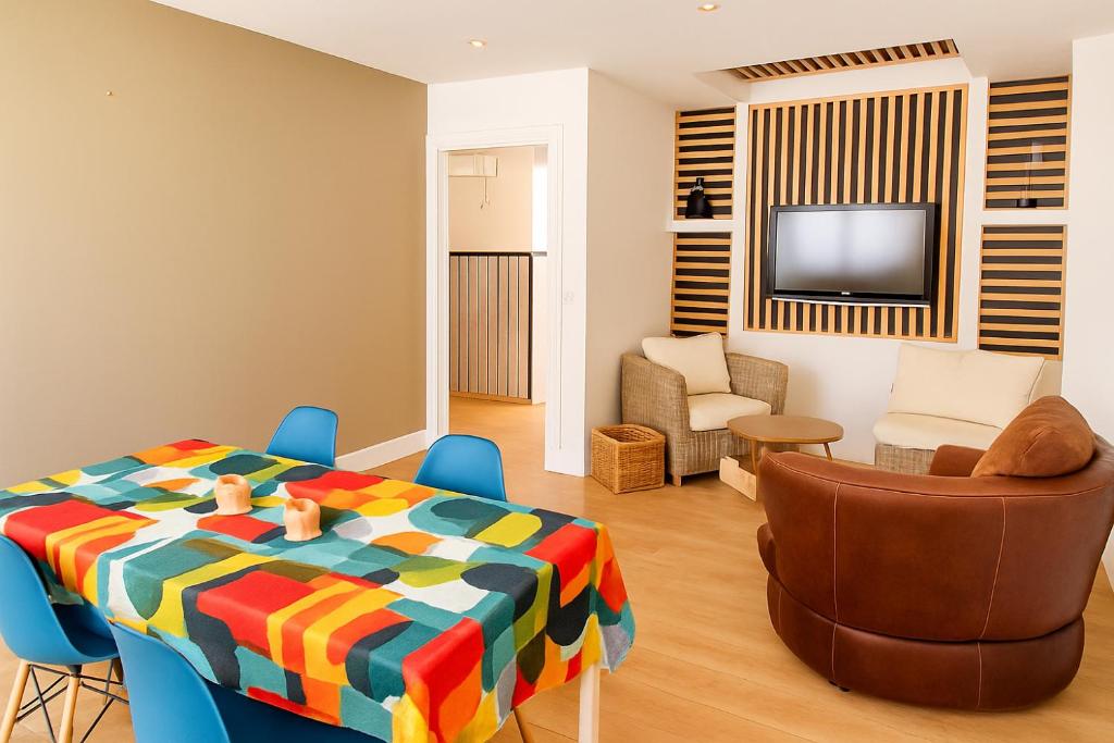 a living room with a table and chairs and a television at T4 coeur de ville, à deux pas de la plage - 3 chambres in Saint-Nazaire