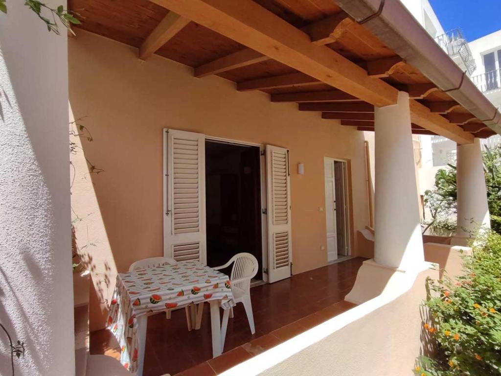 a porch with a table and chairs on a house at Eoliando Case per Vacanze - Lipari Mare in Lipari