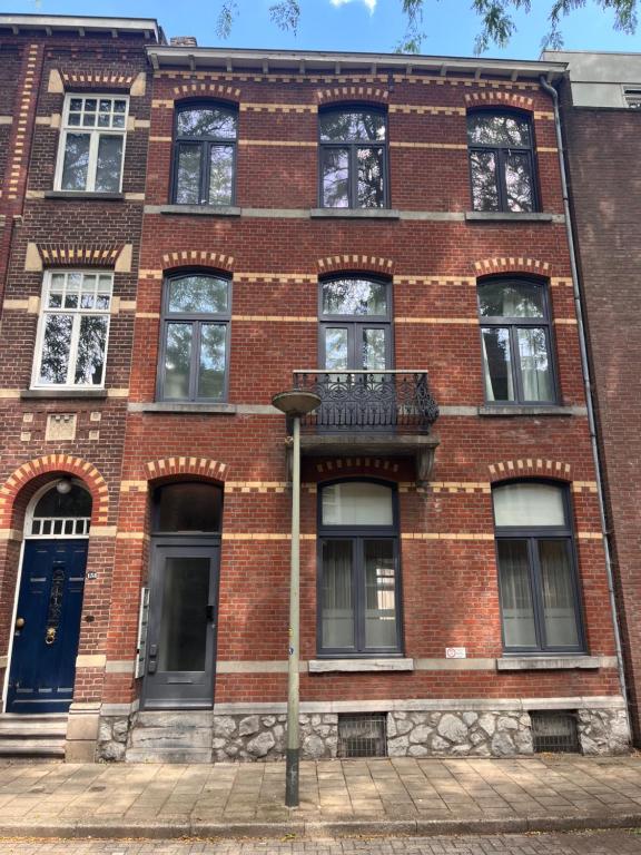 a red brick building with a blue door at naMaaStay in Maastricht