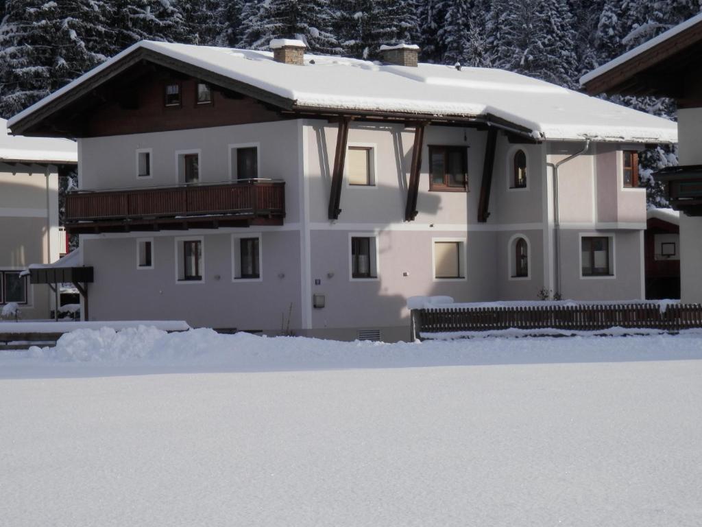 ein weißes Haus mit einem schneebedeckten Dach in der Unterkunft Appartement Nischler in Wald im Pinzgau