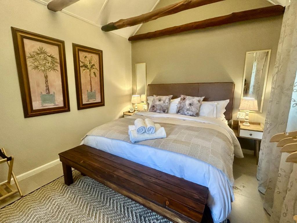 a bedroom with a large bed with towels on it at Rosebud Cottages in George