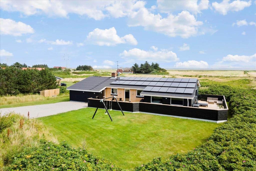 a house with solar panels on top of a yard at 292-Ringkobing-Vestklitvej-12 in Ringkøbing