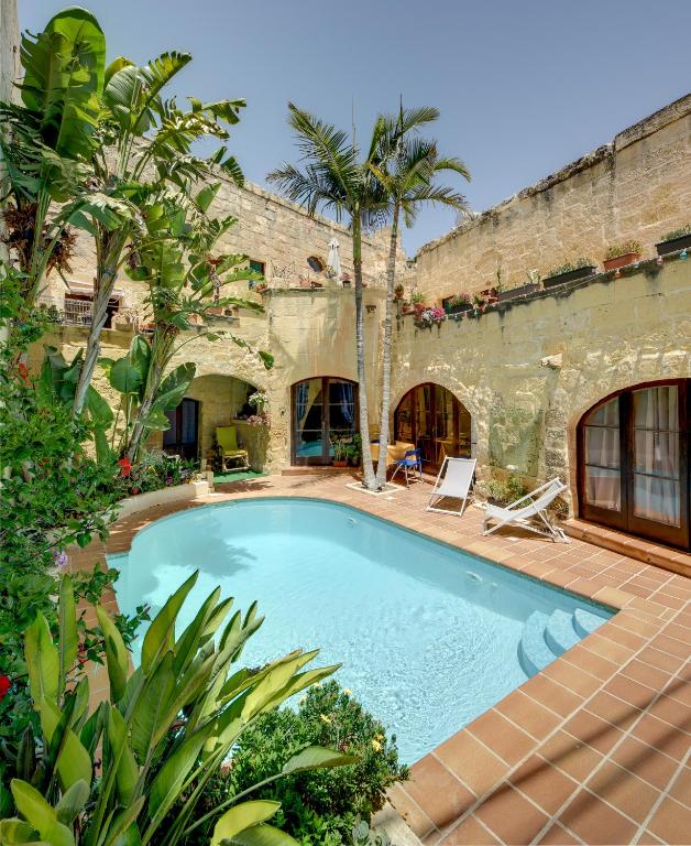 a swimming pool in a house with trees and plants at Serene Escape Farmhouse B&B in San Katald