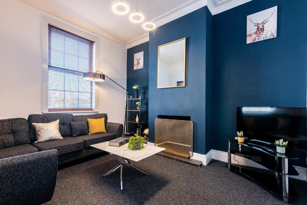un soggiorno con un divano e una TV di Spacious 5BR House in Central Derby - Near Amenities a Derby