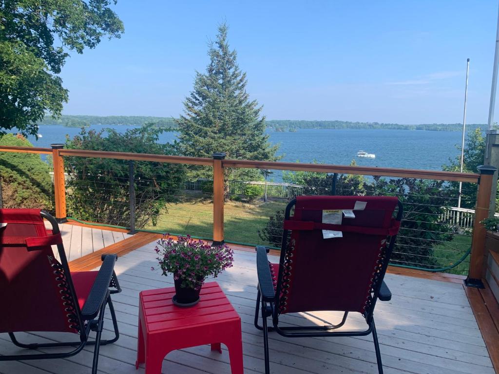 two chairs and a table on a deck with a view of the water at Q Estate Guest Suite heated indoor pool in Westport