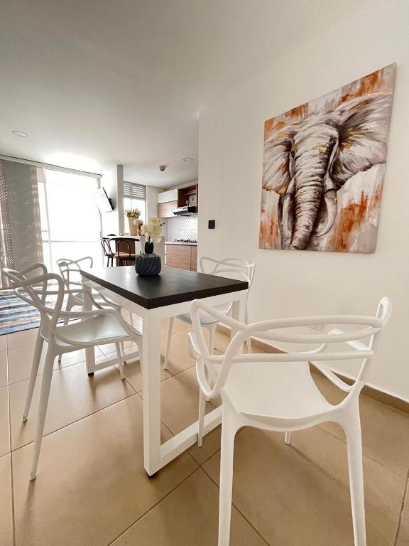 ein Esszimmer mit Tisch und Stühlen und einem Gemälde in der Unterkunft Rest and Perfect Location in Dosquebradas