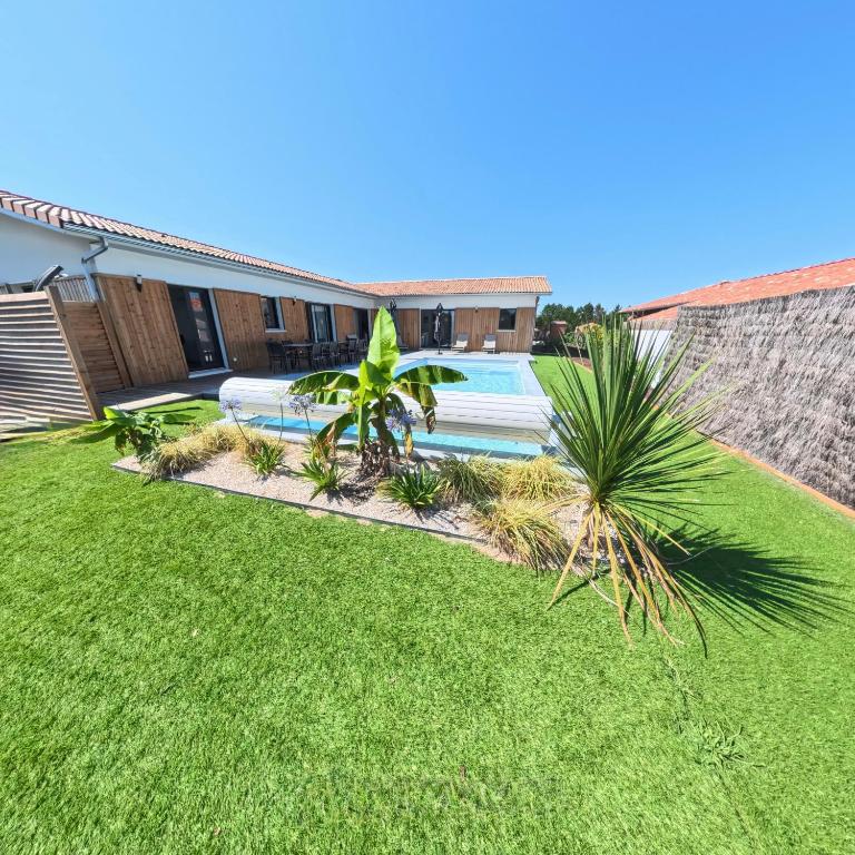 une arrière-cour avec piscine et pelouse dans l'établissement Villa Chrisaline, spacieuse et climatisée, 5 chambres, piscine privée, à Moliets-et-Maa