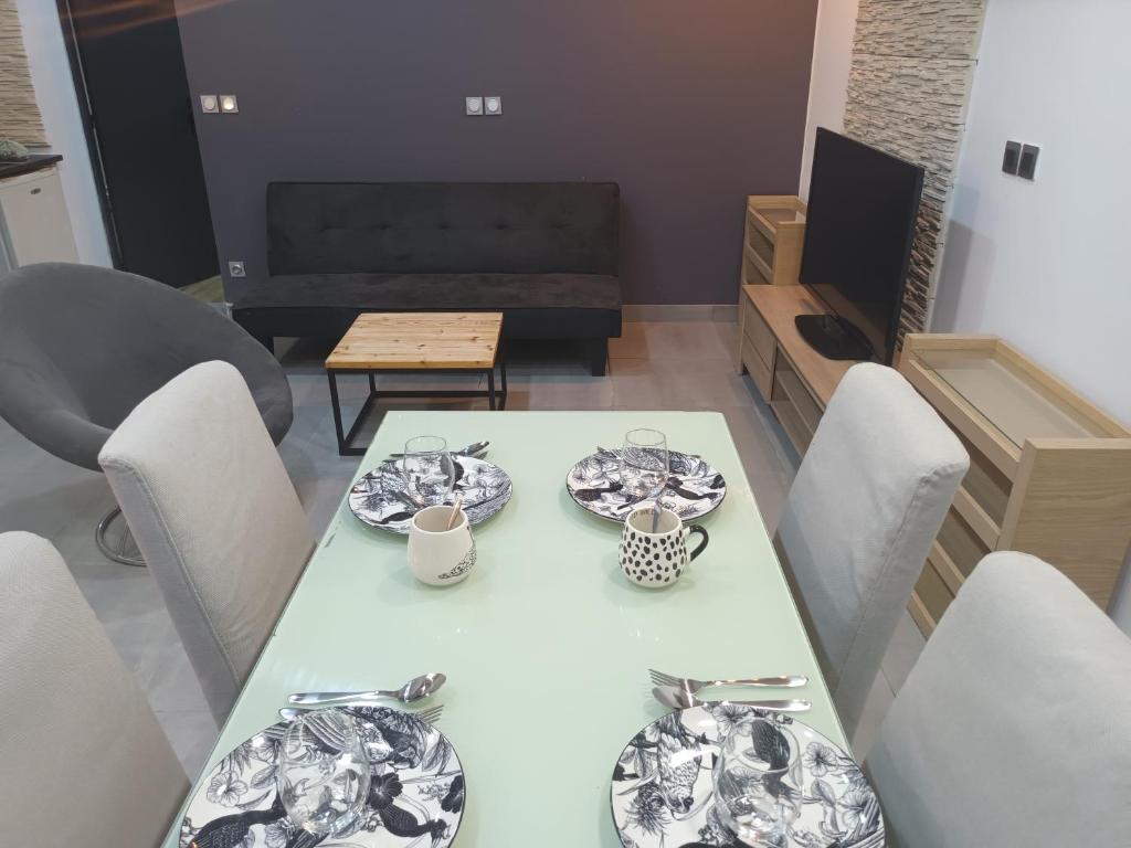a dining room with a white table with plates on it at Nature et calme d'Angers in Saint-Martin-du-Fouilloux