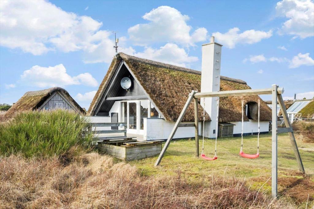 a church with a grass roof with a swing at 2254-Ringkobing-Nordso-Ferievej-52 in Nørre Lyngvig